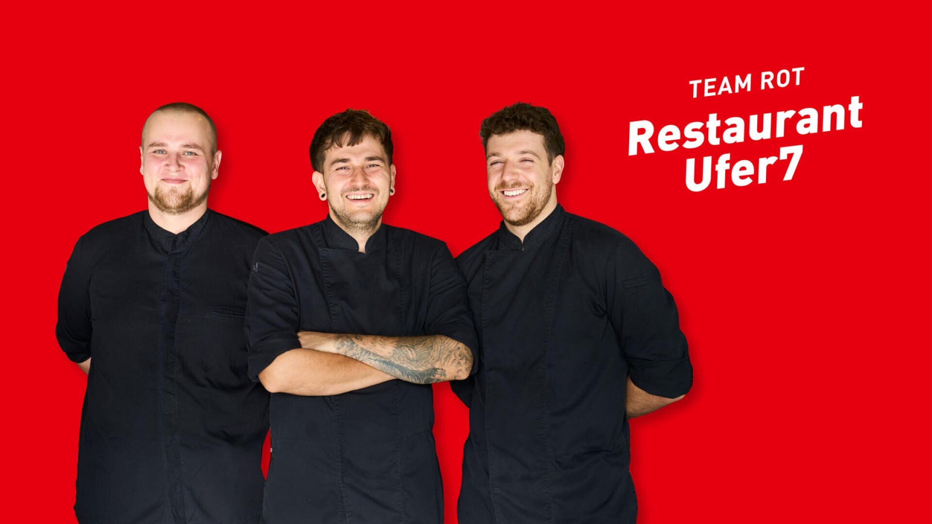 Drei lächelnde Köche in schwarzen Uniformen stehen vor einem roten Hintergrund, darüber steht der Schriftzug TEAM ROT Restaurant Ufer7.