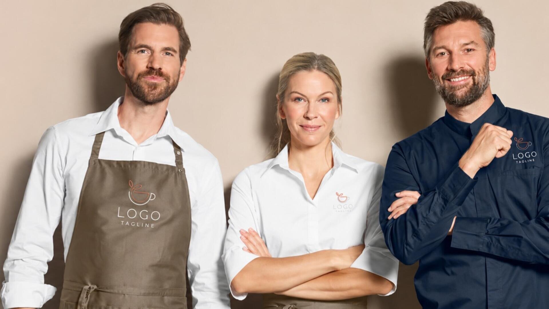 Drei Erwachsene in Uniformen mit Markenlogo stehen lächelnd vor einem neutralen Hintergrund. Zwei tragen braune Schürzen über weißen Hemden, während einer ein marineblaues Hemd trägt. Auf jedem Hemd ist ein Kaffeetassen-Logo sowie der Schriftzug „LOGO TAGLINE“ zu sehen.