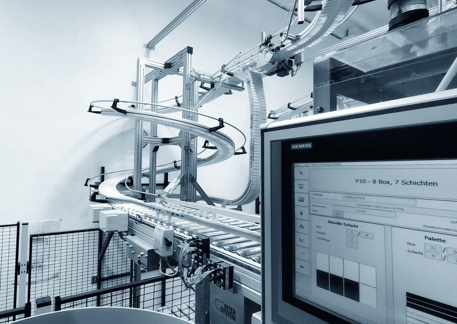 Ein modernes automatisiertes Fördersystem mit einer Spiralrutsche und einem Computermonitor, der die Betriebsdaten in einer Fabrik oder Industrieumgebung anzeigt. Das Bild ist in monochromen Blautönen gehalten.