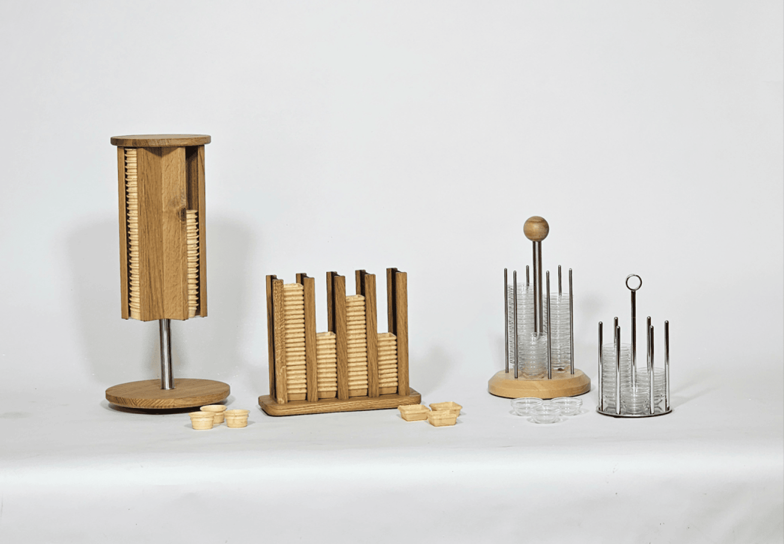 Vier moderne Spielfigurenhalter aus Holz und Metall mit ordentlich gestapelten Spielfiguren aus Holz und transparentem Acryl, präsentiert vor einem schlichten weißen Hintergrund.
