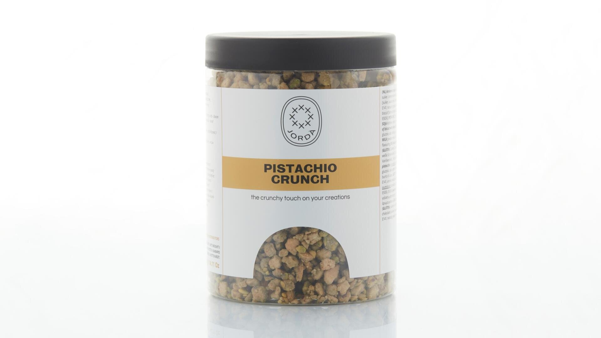 Ein durchsichtiges Plastikglas mit schwarzem Deckel, beschriftet mit „Pistachio Crunch“, in dem knusprige Pistazienstückchen zu sehen sind. Das Etikett besticht durch ein minimalistisches Design mit einem gelben Streifen und einem runden Logo.