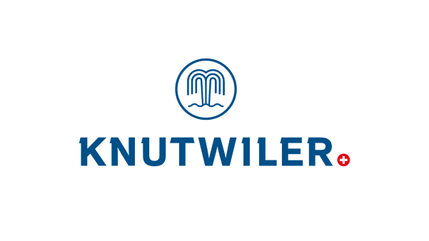 Logo mit einem blauen Springbrunnen-Symbol über dem fettgedruckten blauen Schriftzug „KNUTWILER“; am Ende des Textes erscheint auf weißem Hintergrund ein kleiner roter Kreis mit einem weißen Kreuz.